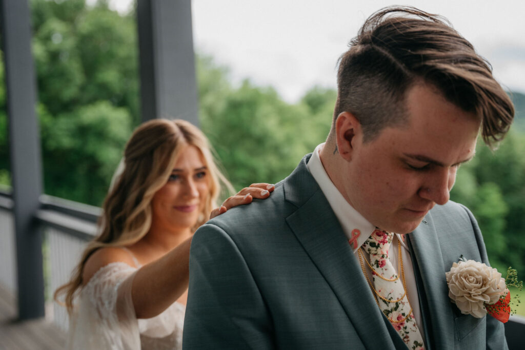 Bride tapping groom’s shoulder for first look in Madison.