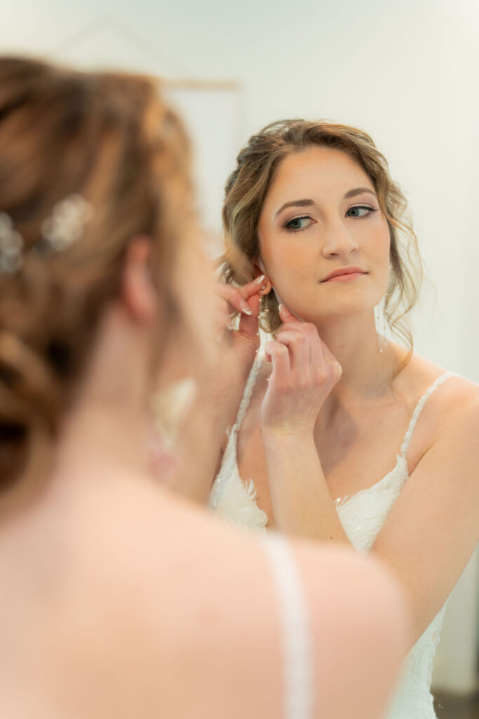 Bride adjusting veil before wedding ceremony.